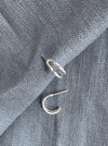 Silver double hooped earrings on a textured grey fabric background