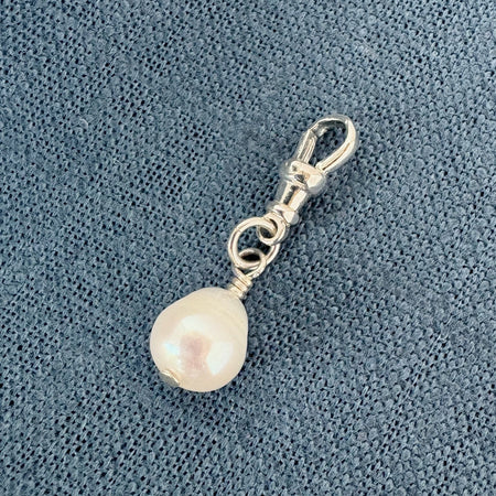 Pearl charm on a blue textured background