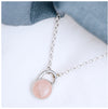 A round rose quartz pendant set in a sterling silver mount, with a chunky silver belcher chain.