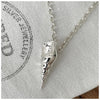 A sterling silver conch sea shell pendant hanging on a 2.5mm belcher chain, displayed against a white background with a Fred & Emily Stamp