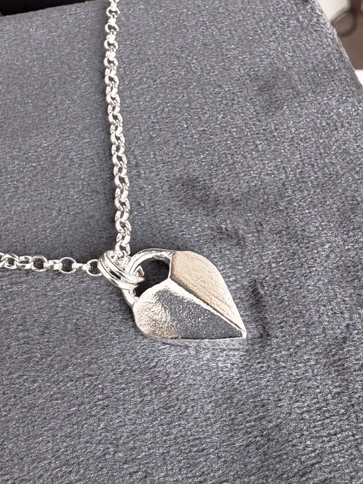 Silver heart-shaped pendant necklace on a soft grey background