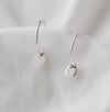 silver hoops with a small pebble on a white linen background