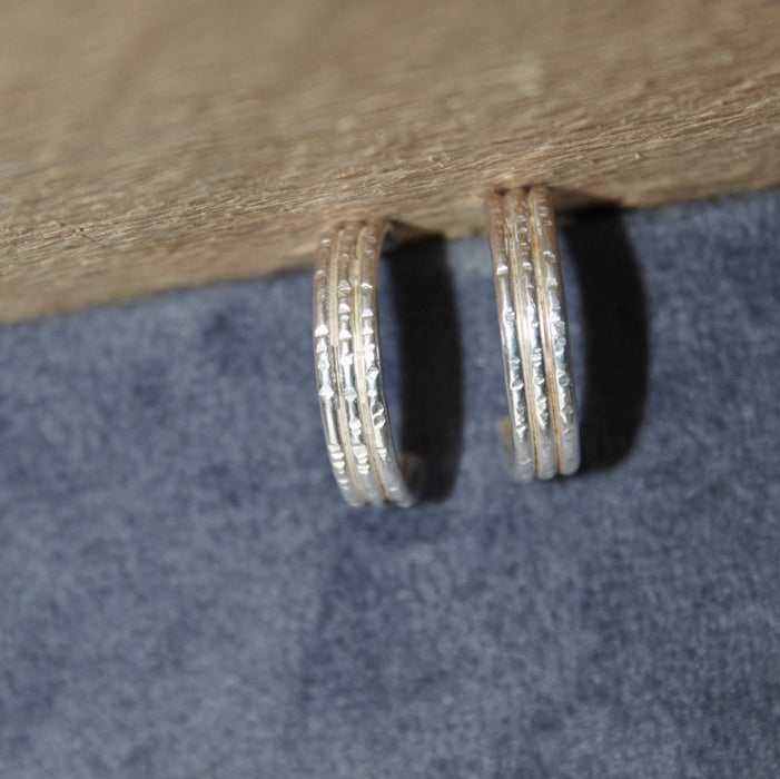 Silver hoop earrings on a wooden surface