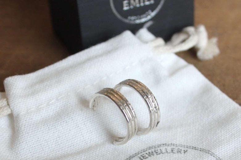 Silver rings on a white jewellery pouch with 'Fred & Emily Jewellery' branding.