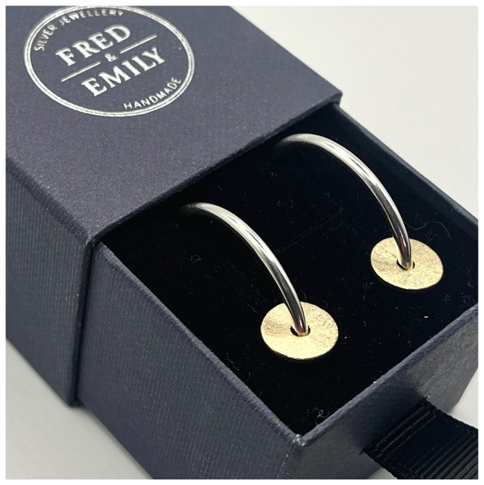 Silver hoops with a gold filled disc, textured to create a sparkle sitting in a blue Fred & Emily Jewellery Box