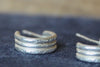 Stack of silver rings on a dark fabric background