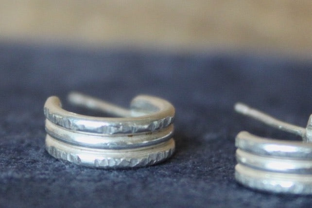 Stack of silver rings on a dark fabric background