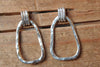 Pair of silver hoop earrings on a wooden surface