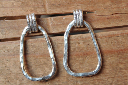Pair of silver hoop earrings on a wooden surface