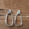 Pair of silver hoop earrings on a wooden surface