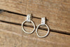 Pair of silver hoop earrings on a wooden surface