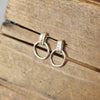 Pair of silver hoop earrings on a wooden surface