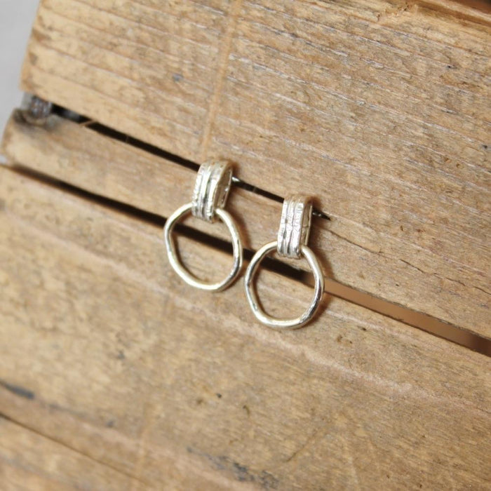 Pair of silver hoop earrings on a wooden surface