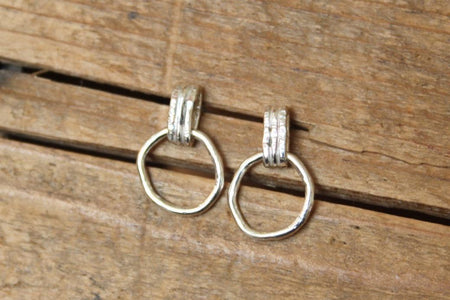 Pair of silver hoop earrings on a wooden surface
