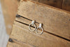 Pair of silver hoop earrings on a wooden surface