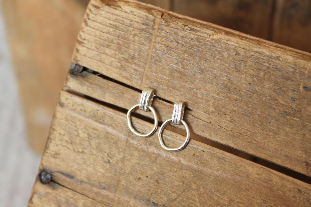 Pair of silver hoop earrings on a wooden surface