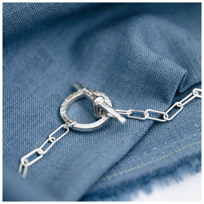 A Trace Chain necklace with a decorative t bar and clasp at the front