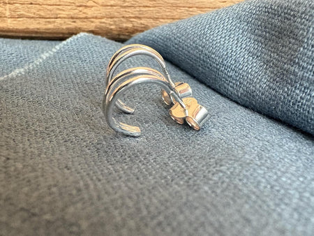 Silver double hooped earrings on a textured surface