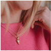 A 9ct gold heart-shaped pendant necklace worn on top of a pink jumper