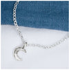 A silver crescent moon pendant on a chain, displayed against a blue textured background.