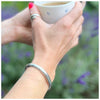 silver cuff on lady drinking tea
