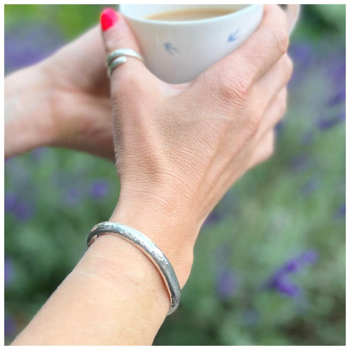 silver cuff on lady drinking tea