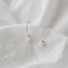 silver hoops with a small pebble on a white linen background