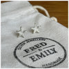 Starfish stud earrings made from sterling silver sitting on a white linen bag