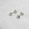 Small Globe studs, made from silver laying on a white linen background